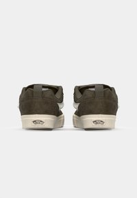 Pair of dark olive Vans sneakers with white soles, viewed from the back, featuring the "Off The Wall" logo on the heel.