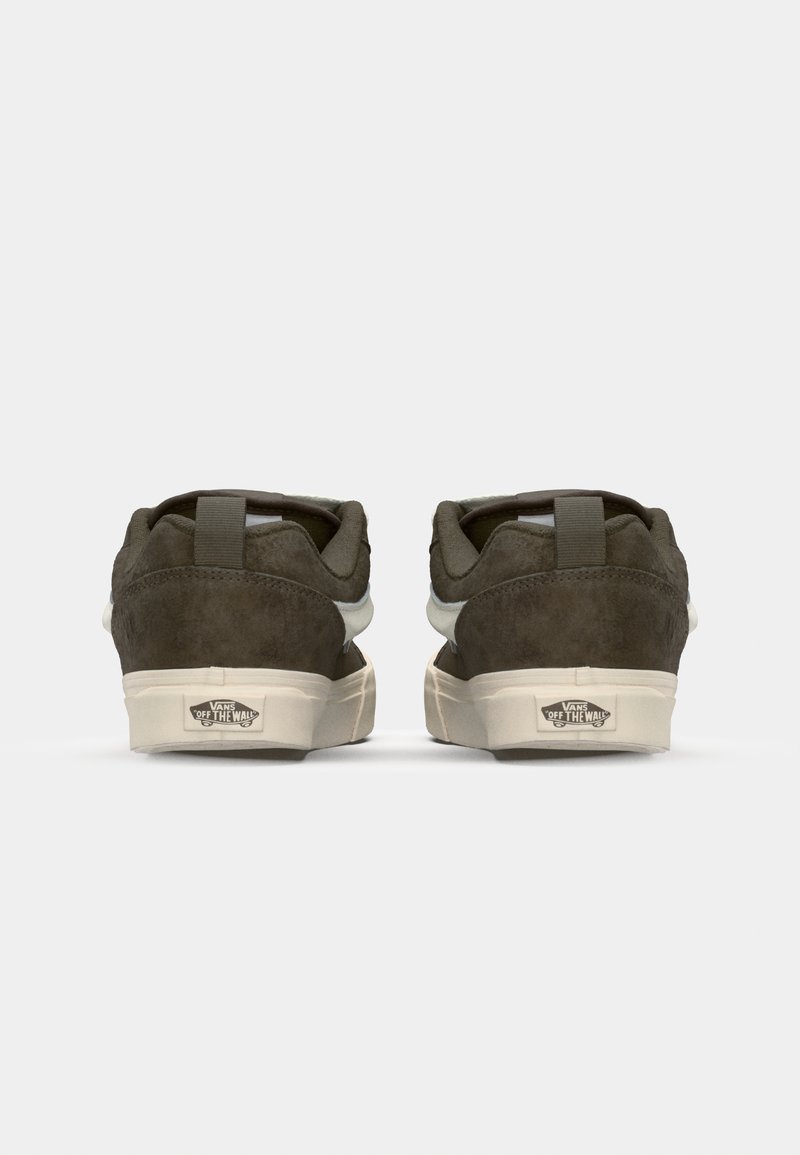 Ein Paar dunkle olivfarbene Vans-Sneakers mit weißen Sohlen, von hinten betrachtet, mit dem "Off The Wall"-Logo auf der Ferse.