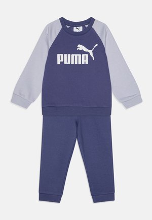 Sudadera azul marino y gris claro con mangas largas tipo raglán, que cuenta con un gran logotipo blanco de "PUMA" en la parte frontal, combinada con pantalones a juego.