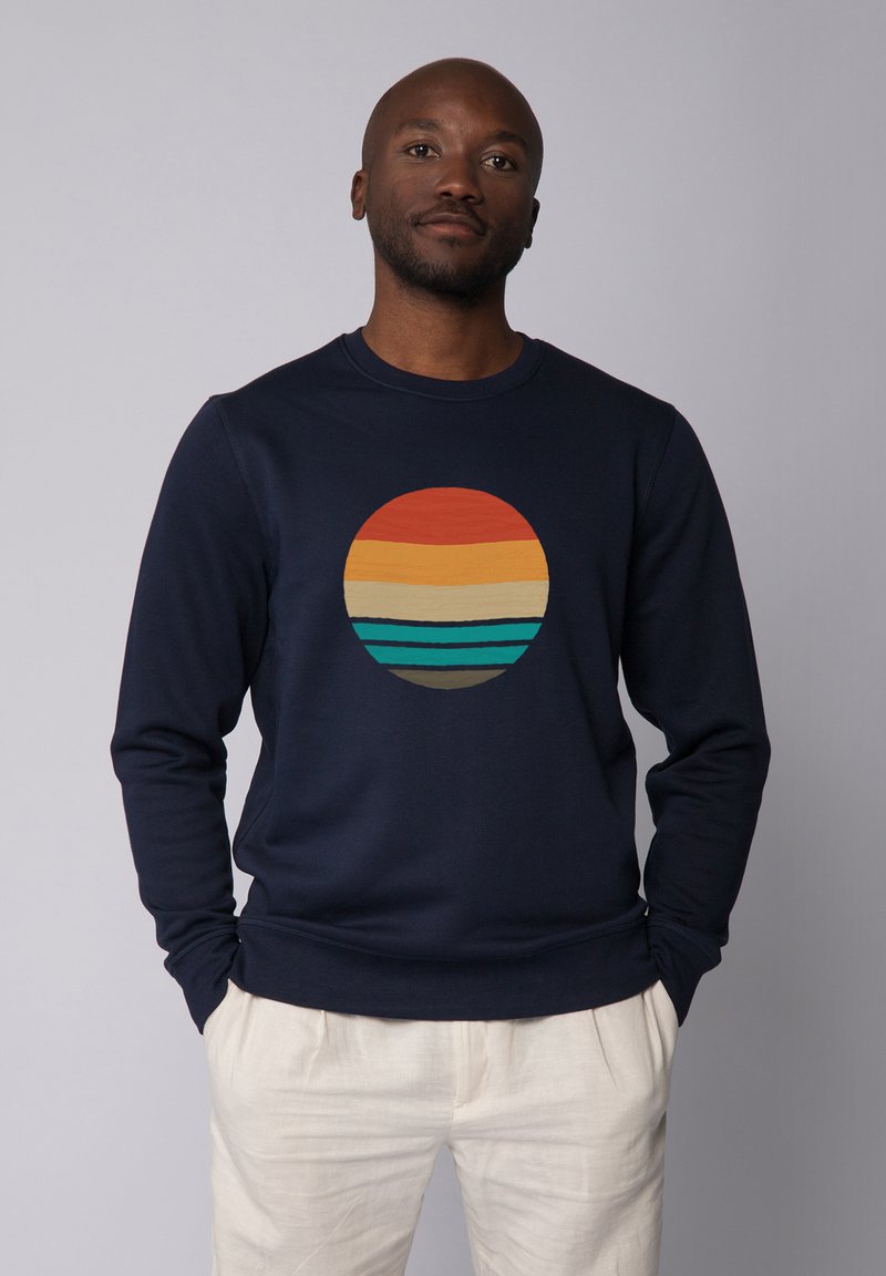 Navy Sweatshirt mit einem runden Grafikdesign, das horizontale Streifen in Orange, Gelb und Türkis zeigt. Aus weichem Stoff und mit Rundhalsausschnitt.