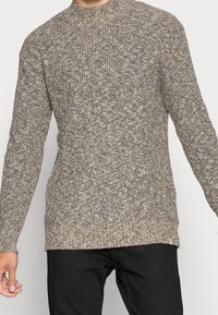 Pullover lavorato a maglia a maniche lunghe, in una fusione di tonalità marroni e grigie, con un collo a girocollo e una finitura strutturata. Morbido, vestibilità rilassata.
