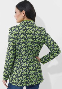 Groen en marineblauwe blazer met een aangesloten ontwerp, reverskraag en lange mouwen, voorzien van een bloemenmotief over de stof.