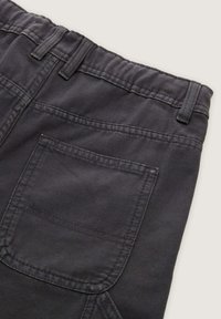 Donkergrijze broek met een geweven stof, elastische tailleband en een achterzak met verstevigde stiksels.