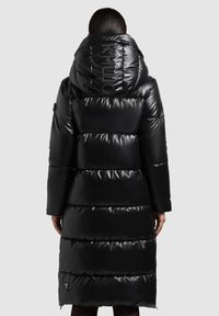 Crna pernata jakna visokog ovratnika sa sjajnom teksturom, s horizontalno prošivenim panelima i logotipom na kapuljači. Dugi rukavi i detalj sa patentnim zatvaračem.