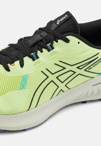 Scarpa sportiva verde lime con upper in rete nera, accenti blu e lacci neri. Presenta una superficie texture e una suola imbottita con scanalature.