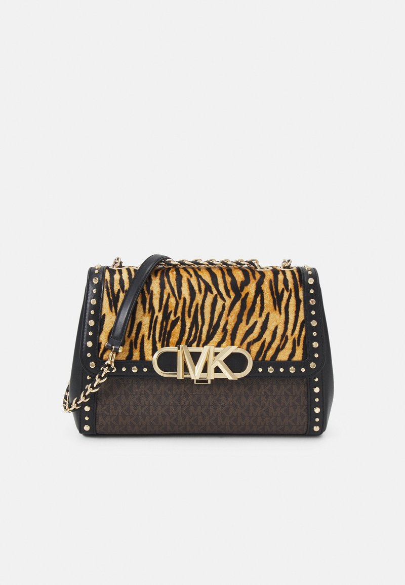 Sac à main noir avec rabat en fourrure imprimé tigre, ferrures dorées, accents cloutés et logo MK. Matériaux texturés et forme structurée.