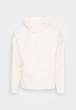 Veste légère blanche à capuche avec poche kangourou devant et fermeture par cordon au niveau du cou et de la capuche.
