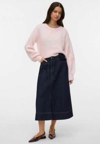 Różowy sweter z dzianiny z kwiatową haftem, zestawiony z ciemną spódnicą dżinsową z różowym akcentem w talii i prostą sylwetką.