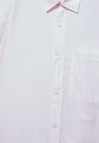 Chemise habillée blanche avec de fines rayures verticales roses, devant boutonné et poche poitrine du côté droit.