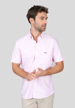 Chemise à manches courtes rose clair avec col button-down et logo sur la poitrine gauche. Présente une texture lisse et un design à coupe standard.