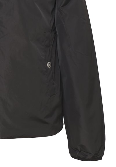 Giacca nera con un tessuto liscio e leggero, caratterizzata da un colletto alto, polsini elasticizzati e una tasca laterale con chiusura a bottone.