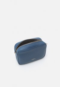 Blå läder kosmetikväska med en strukturerad rektangulär form, med en guldfärgad dragkedja och präglad varumärkeslogotyp på framsidan.