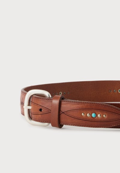 Ceinture en cuir marron avec boucle argentée, couture décorative et petits clous métalliques, dont un clou central turquoise.
