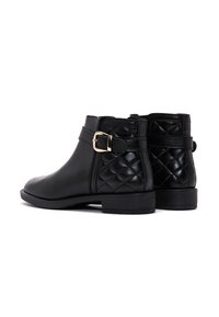 Botas negras de cuero hasta el tobillo con patrón acolchado en los lados, detalle de hebilla dorada, tacón bajo y diseño de punta redonda.
