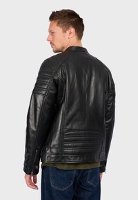 Černá kožená motorkářská bunda s prošívanými ramenními akcenty, zipovými manžetami a texturovaným zadním panelem. Klasický design límce.