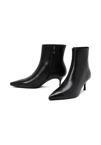 Botines de cuero negro hasta el tobillo con punta afilada y tacón fino. Cuentan con una cremallera lateral y una textura suave.