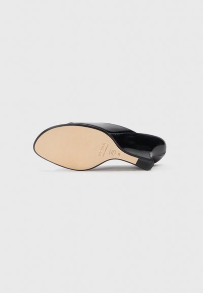 Black leather heeled shoe with a smooth upper, open back design, rounded toe, and a beige sole featuring branding details.
