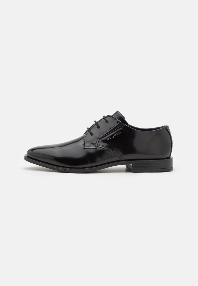 Chaussure de ville noire brillante pour homme à lacets, avec un petit talon et le nom de la marque embossé sur le côté, sur un fond uni.