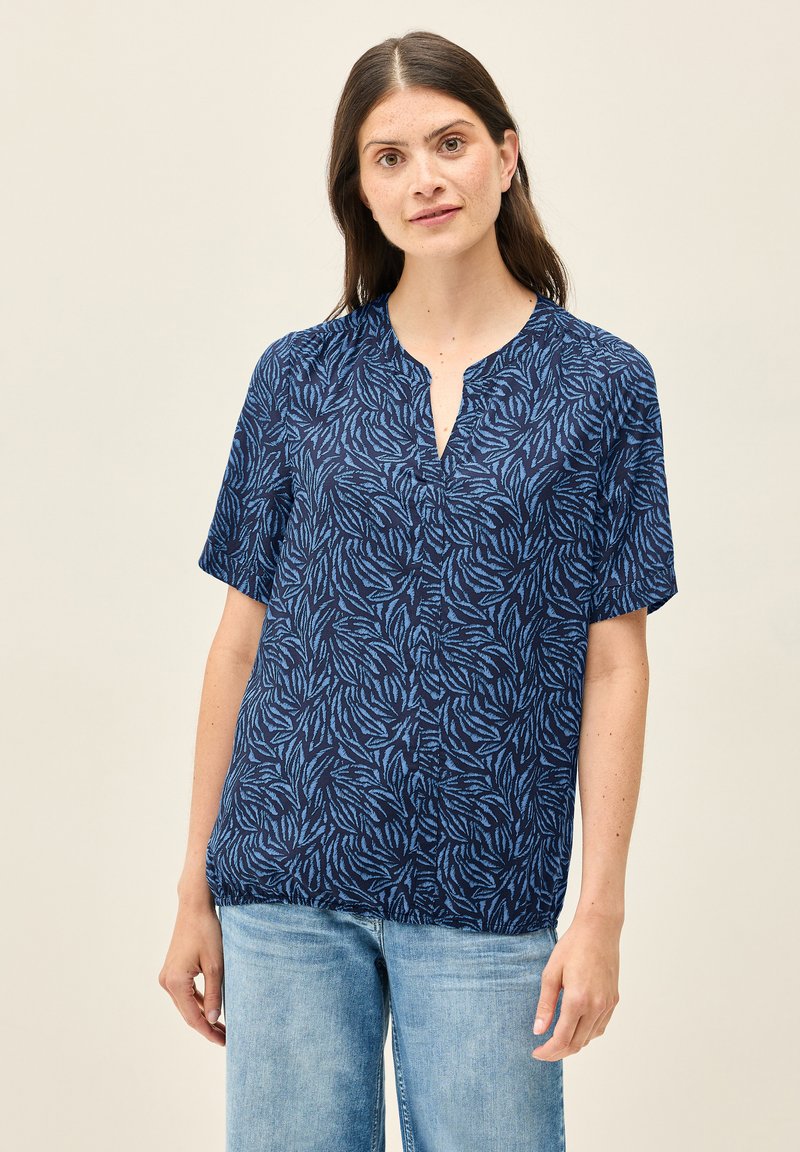 Blusa blu scuro con maniche corte, caratterizzata da un motivo a foglie blu. Design a V con dettaglio a bottone. Tessuto leggero, vestibilità comoda.
