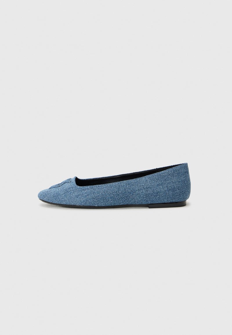 Denim ballet flat with a rounded toe and a small bow detail on the front, features a textured blue upper and a black interior lining.