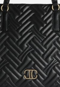 Borsa trapuntata nera con texture intrecciata, caratterizzata da accessori dorati e un logo prominente alla base, completata da cinturini in pelle nera.