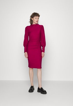 Fitted põlveliha pikkune kleit magenta värvuses, millel on puff käised, külgmine kortsutus ja vale kaelus. Kandmiseks mustade pläterdatud kingadega.