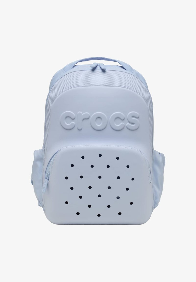 Light blue Crocs backpack with front zippered pocket featuring ventilation holes and embossed brand name on main compartment.