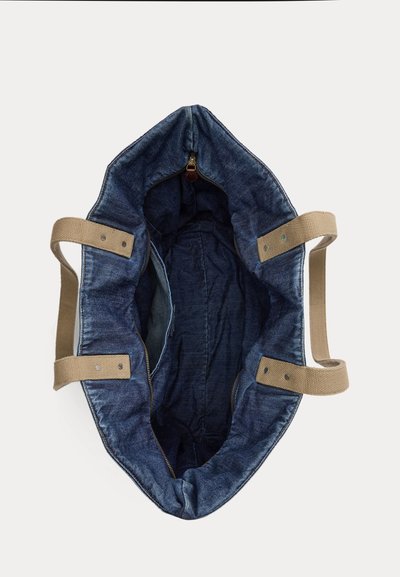 Τσάντα tote από τζιν με μπεζ υφασμάτινες λαβές, κλείσιμο με φερμουάρ και ευρύχωρο, χωρίς επένδυση εσωτερικό, απεικονιζόμενη από πάνω.