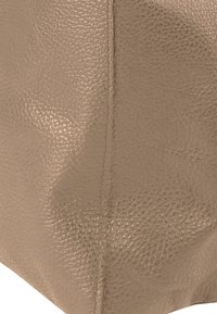 Beige handtas van imitatieleren met een gestructureerd oppervlak en gestikte naden, met een vierkante vorm en minimalistisch ontwerp.