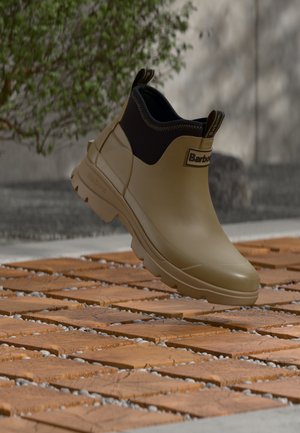 Barbour rubber enkellaars in olijfgroen met een zwarte neopreen manchetten, voorzien van een gestructureerde zool, logo-accenten en een gladde afwerking.