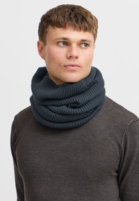 Tumehall ribatud igavene sall pehme tekstuuriga, millel on kihilised voldid ja väike brändimärk küljes.