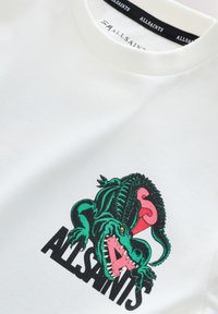 Witte katoenen T-shirt met een kleurrafische afbeelding van een groene krokodil met roze accenten en zwarte tekst met "ALLSAINTS" daaronder.