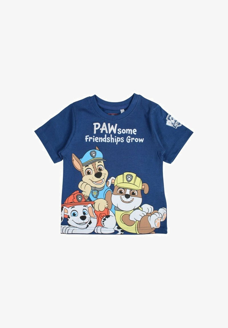 T-shirt en coton bleu avec des personnages de chiens de dessin animé, portant le texte "Des Amitiés Pattes à Pattes" en blanc au-dessus d'eux. Manches courtes et encolure ronde.