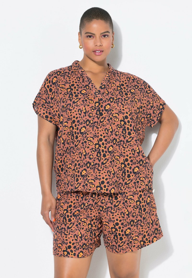 Lepelprint tweedelig outfit in oranje en zwart, gemaakt van lichtgewicht stof. Heeft een gekraagde top met korte mouwen en bijpassende shorts.