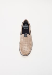 Beige slip-on sko med perforeret design, sorte accenter og blødt indre foer. Rund tå og fleksibel sål for komfort. Brandlogo synligt.
