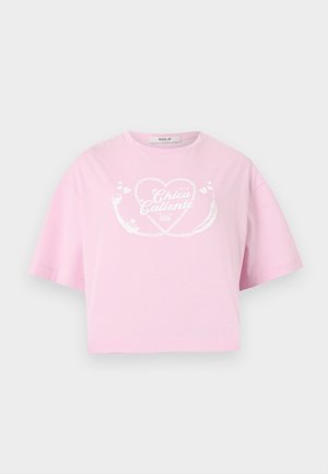 Tricou roz deschis scurt, cu design alb în formă de inimă și textul „Chica Caliente” pe față, mâneci scurte și decolteu rotund.