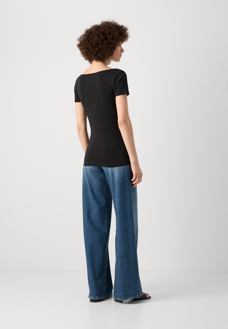 Top noir à manches courtes avec un décolleté carré, associé à un jean en denim bleu décontracté. Texture lisse et design casual.