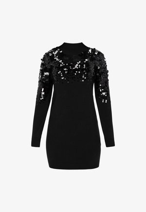 Fekete, hosszú ujjú pulóverruha magas gallérral, nagy fekete flitterekkel, amelyek sűrűn borítják a vállakat és a felső karokat.