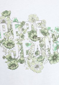 Tela blanca con un patrón floral en verde y beige claro, que presenta grandes letras blancas que parcialmente deletrean "PEPE JEANS."