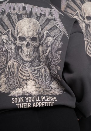 Black sweatshirt featuring a prominent graphic of a skull, roses, and skeletons, with metallic accents and text that reads "SOON YOU'LL PLEASE THEIR APPETITE."