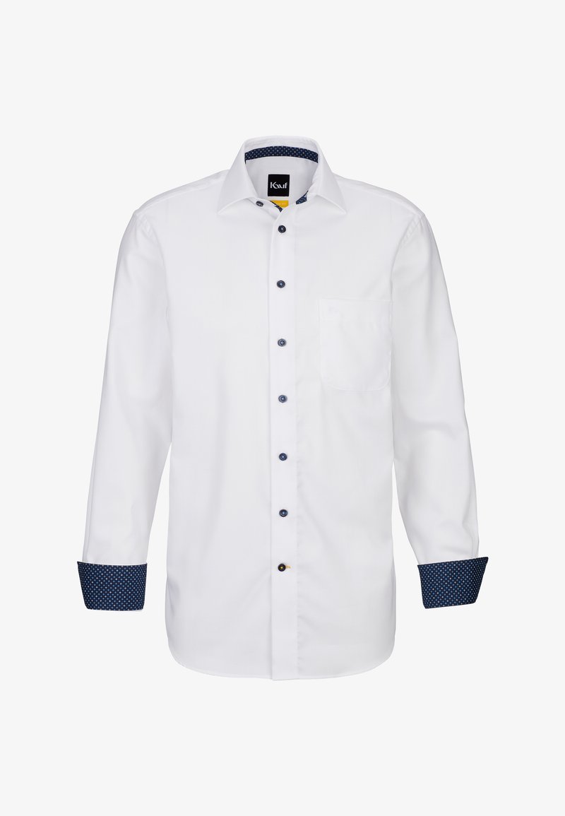 Camicia bianca a maniche lunghe con chiusura a bottoni. Accenti blu navy sui polsini e sul colletto, con un sottile motivo a pois. Inclusa tasca frontale.