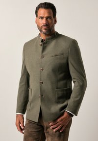 Blazer de lana verde oliva con cuello alto, que presenta cinco botones, un bolsillo en el pecho y dos bolsillos frontales con costuras en contraste.