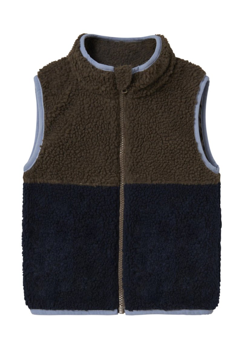 Pruun ja meresinine fliisvest kõrge kraega, lukuga ning sinise voodriga. Omab tekstuuriga mugavat kangast ja värvilahendusega disaini.