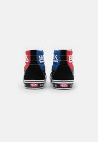 Adidași înalți din suede negru, cu accente roșii și albastre, cusături albe și patch cu brand pe toc. Textul este afișat în coreeană și engleză.