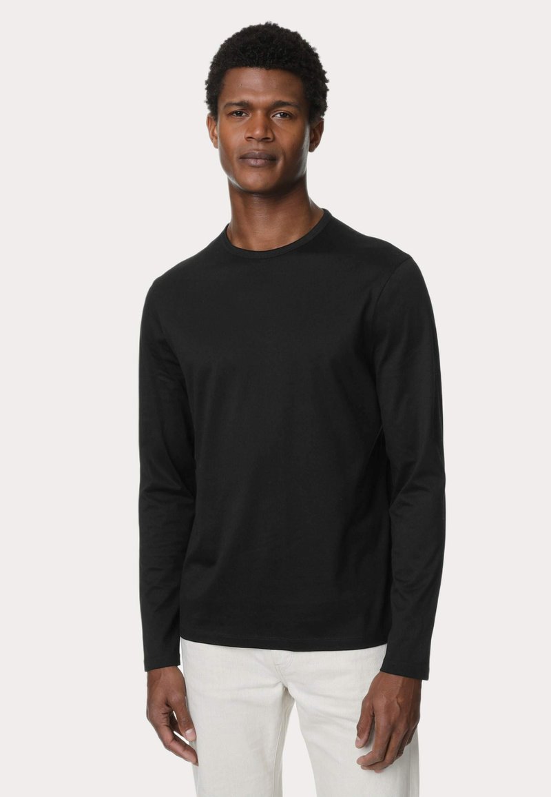 Camiseta negra de manga larga en corte ajustado con cuello redondo, hecha de algodón, con una textura suave y sin patrones ni acentos visibles.