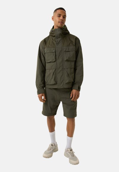 Olive green jacket with four front pockets, hood, and snap closures, paired with matching shorts. Features lightweight, smooth fabric and shoelace accents.