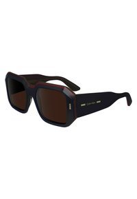 Ochelari de soare negri și roșii cu o formă rectangulară, rame groase și lentile maronii. Prezintă accente metalice subtile pe brațe.