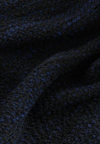 Textured fabric featuring a blend of dark blue and black fibers, displaying a soft, fuzzy surface with a dotted pattern.
