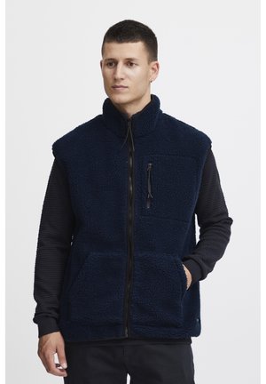 Chaleco de forro polar navy con cuello alto, cremallera frontal completa, dos bolsillos frontales y un bolsillo en el pecho con cremallera, con tejido texturizado.