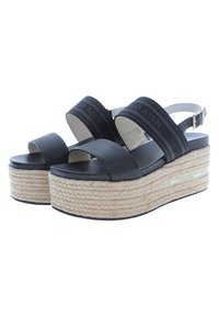 Sandalias de plataforma negras con dos correas anchas, una plataforma de estilo esparto texturizada y una correa trasera con un detalle de hebilla dorada.